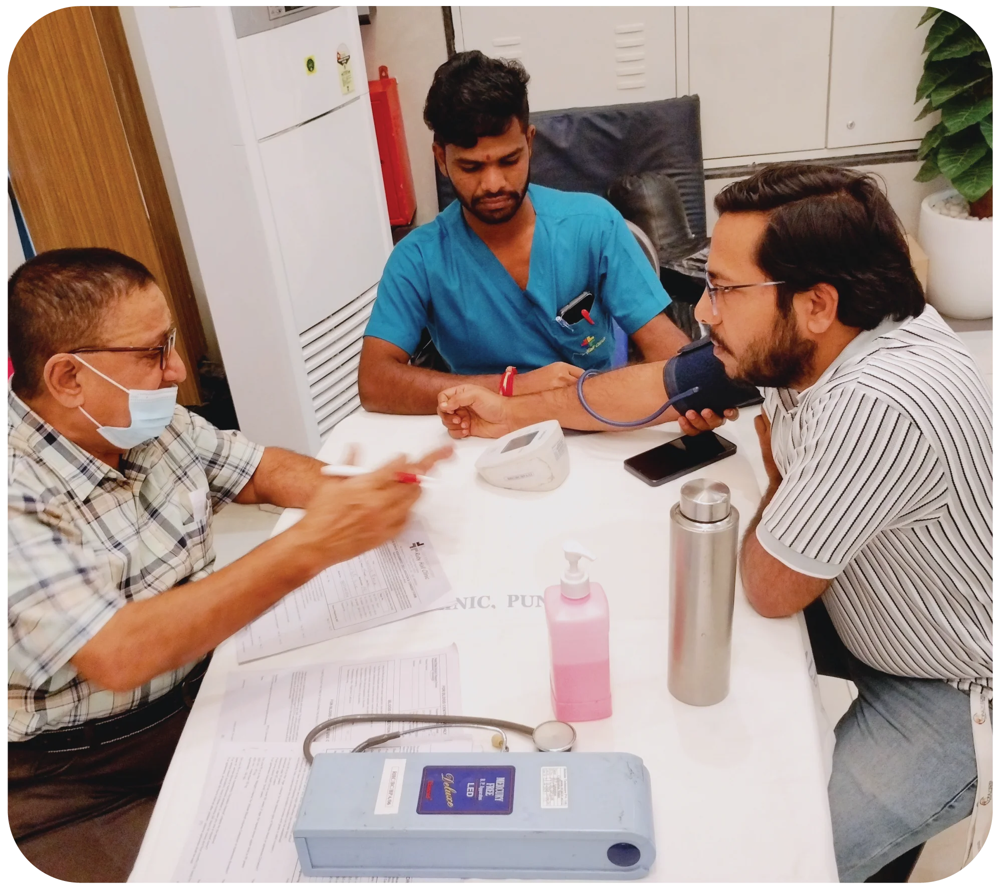 Medical staff assisting a donor during blood donation on a recliner chair